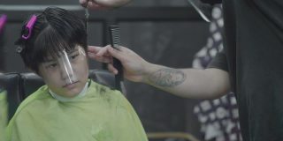 亚洲男孩坐在理发店剪发