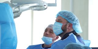 临床医学手术。专业医生用特殊设备为病人做手术。戴口罩的外科医生进行手术。