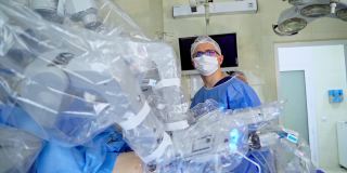 外科医生靠近医疗设备的机械臂。医用机器人在现代手术室的微创手术。未来的操作。