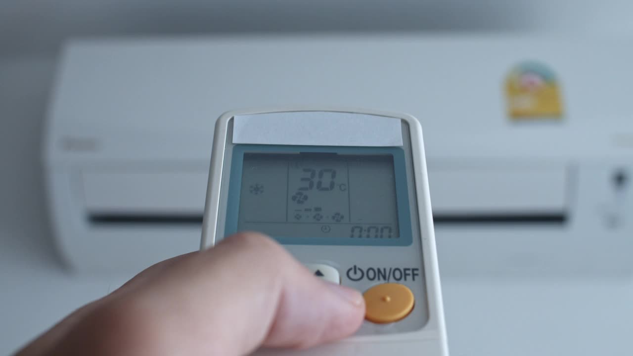 用遥控器将温度降低到25度。