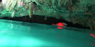 在墨西哥图卢姆，和飞翔的蝙蝠一起在“大天然井”(Gran Cenote)天然石灰岩洞穴中游泳