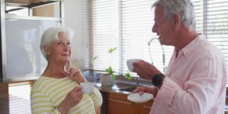 快乐的白人老年夫妇在厨房喝咖啡聊天时，粉红色的良好氛围的动画