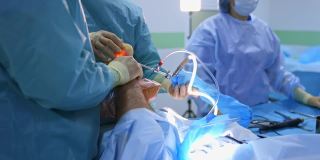 手术过程。医务人员在医院里用现代医疗工具对病人的腿进行手术。卫生保健的概念。
