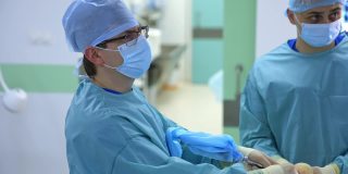 在手术室工作的医生。专业的外科医生和护士团队用医疗设备为患者进行手术。特写镜头。