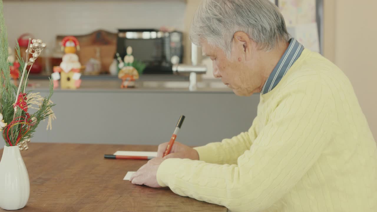 一名日本老人正在写新年贺卡