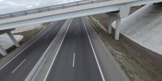 快速飞行高速公路fpv运动无人机在高速公路沥青路面上与驾驶汽车，汽车，卡车