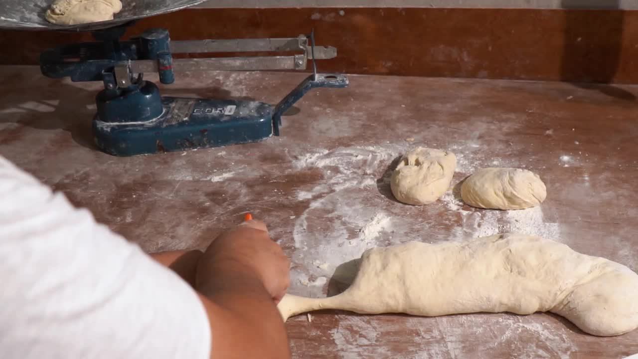 一个无法辨认的面包师，他把生面团分成相等的部分并称重