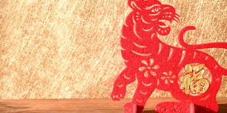 潘观中国新年老虎2022吉祥物剪纸在木桌上的早晨，中国的意思是财富没有标志没有商标