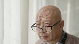 窗前的一位中国老人，戴着老花镜，凝视着前方视频素材模板下载