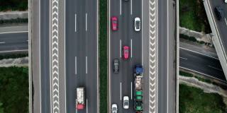 从无人机上俯视大城市多车道高速公路现代交通枢纽。高速公路上交通拥挤。跟随正确方向的车辆。