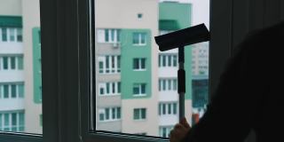 员工手擦玻璃。用橡皮擦清洁窗户