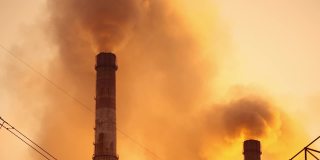 环境灾难。工厂烟囱里喷出的化学烟雾污染着日落时的空气。工业造成的大气污染。