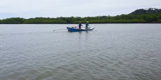 父亲和儿子在河上的船上捕鱼