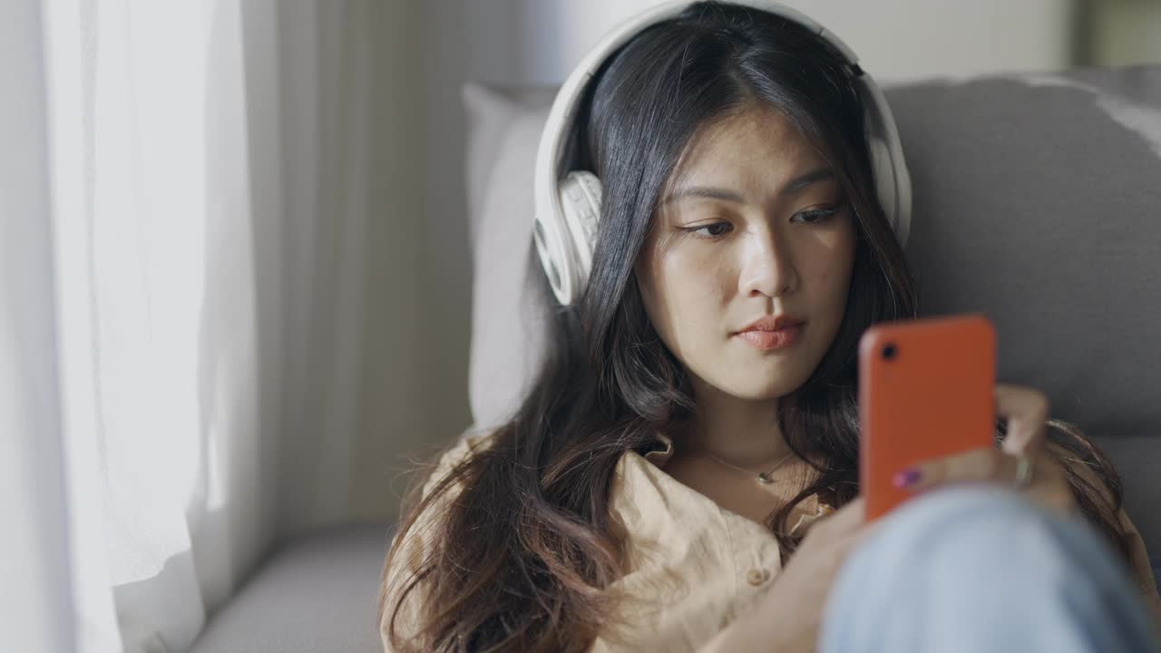 亚洲女性在家里使用智能手机