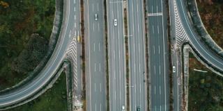 从无人机上俯视大城市多车道高速公路现代交通枢纽。高速公路上交通拥挤。跟随正确方向的车辆。