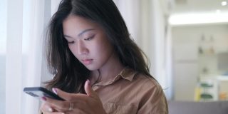 亚洲女性在家里使用智能手机