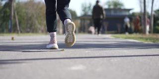 慢动作低角度跟随一个年轻女子在公园跑步的镜头