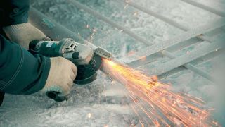 冬季工人用角磨机处理金属门，火花飞舞。特写的慢动作视频视频素材模板下载