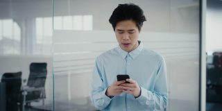 韩国企业家使用智能手机浏览互联网，在办公室行走