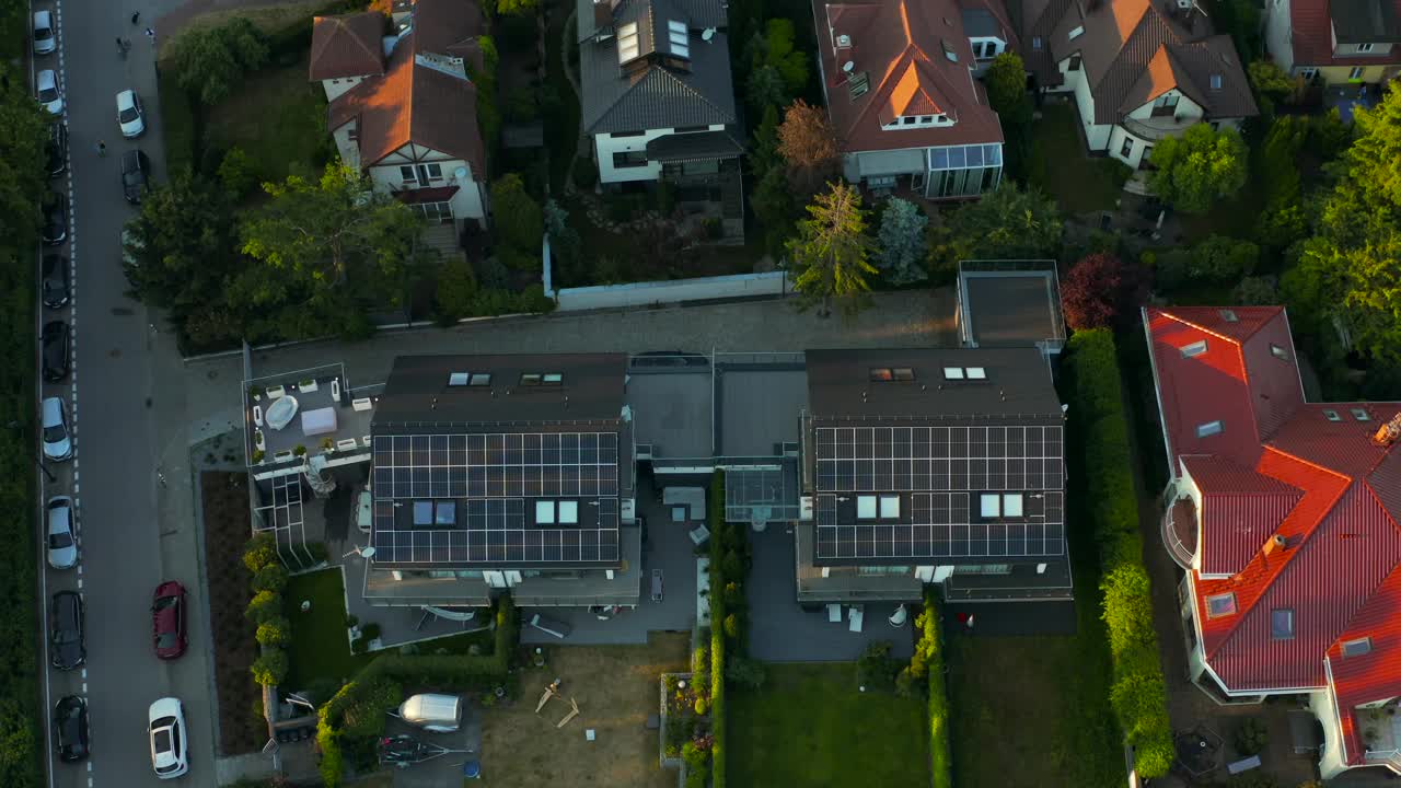 一架无人机瞄准了一座屋顶装有太阳能光伏板系统的现代住宅小屋。可再生生态绿色能源生产理念。可持续能源。技术。