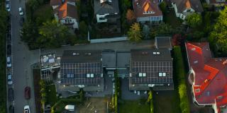 一架无人机瞄准了一座屋顶装有太阳能光伏板系统的现代住宅小屋。可再生生态绿色能源生产理念。可持续能源。技术。