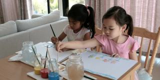 年轻的混血女孩画水彩画，蒙特梭利家庭学校教育，多样性友谊的概念