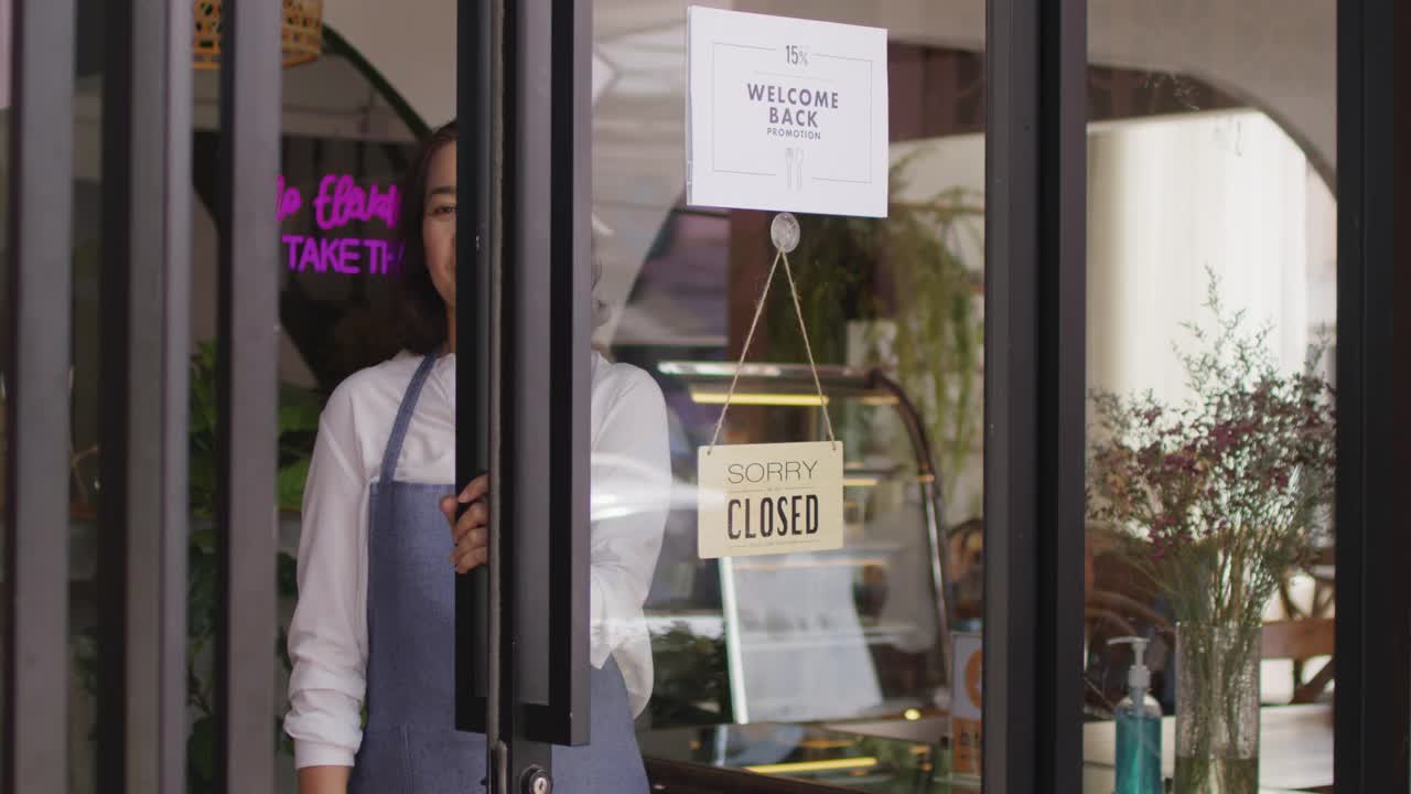 成熟的女性酒吧酒吧中小企业老板开门欢迎新冠疫情后的咖啡馆。