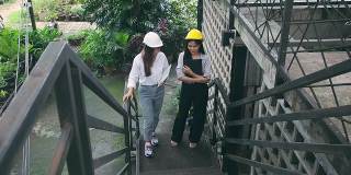 两个年轻的女建筑师边走边聊天。