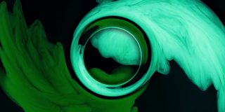 抽象圆形绿色墨水从上面滴下来，在水中混合，在黑色背景下轻轻旋转