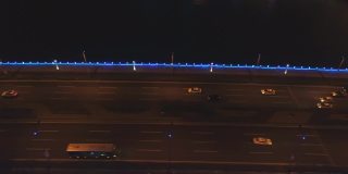 现代城市中鸟瞰桥景，全景桥景配照明。河上大桥夜间交通鸟瞰图。