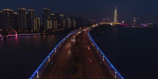 现代城市中桥的鸟瞰图，带照明的桥的全景。河上大桥夜间交通鸟瞰图。