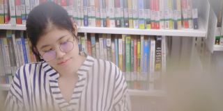 亚洲女孩坐在图书馆看书