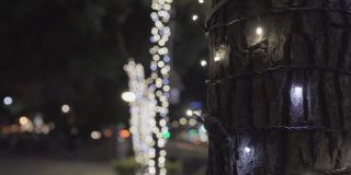 闪亮的圣诞装饰品。挂在树上。模糊的背景是道路和汽车。主题在右边。