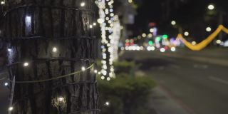 闪亮的圣诞装饰品。挂在树上。模糊的背景是道路和汽车。实验对象在左边。