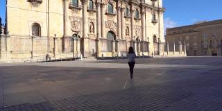 一位妇女走在安达卢西亚耆恩大教堂的广场上。