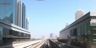 地铁系统。清晨从迪拜地铁车厢窗口看到的景色。地铁列车经过摩天大楼。时间流逝
