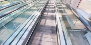 空扶梯下行背景，概念运动路径。移动走道在机场铁路候机楼，直线平坦旅行