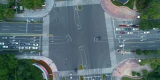 无人机拍摄的城市十字路口，汽车和公交车行驶在大道上。在日落时