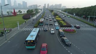 无人机拍摄的城市十字路口，汽车和公交车行驶在大道上。在日落时视频素材模板下载