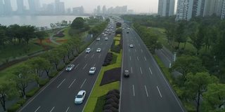 鸟瞰图的汽车运行在城市道路上的日落，中国。