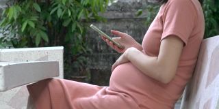 女性等待她的孩子，亚洲孕妇看她的超声波扫描照片手机