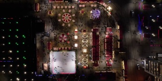 圣诞市场，鸟瞰。圣诞旋转木马，溜冰场，巨大的装饰圣诞树和摩天轮。现代城市灯火通明的圣诞集市。