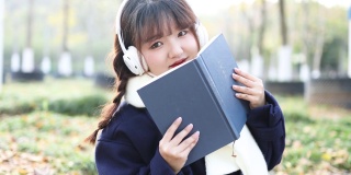 秋天，一个女人在外面听音乐看书。