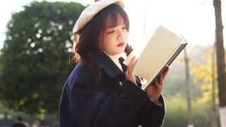 秋天，日落时分，一个女人在外面看书。视频素材模板下载