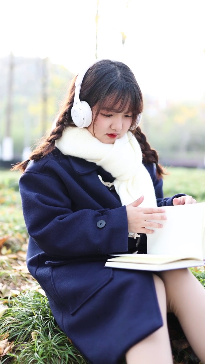 秋天，一个女人在外面听音乐看书。