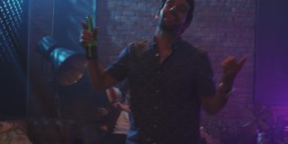 西班牙男人在酒吧的晚会上跳舞喝酒。