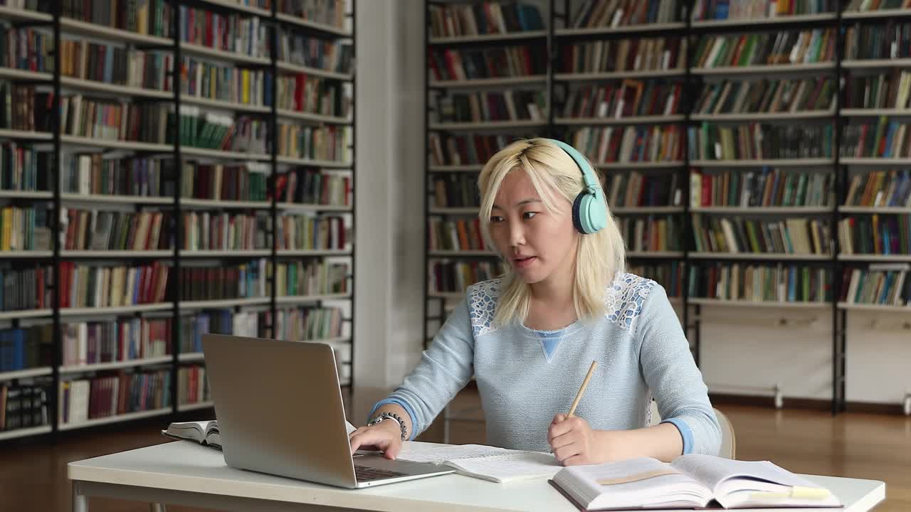 一个女生用笔记本电脑和正在网上学习的老师聊天