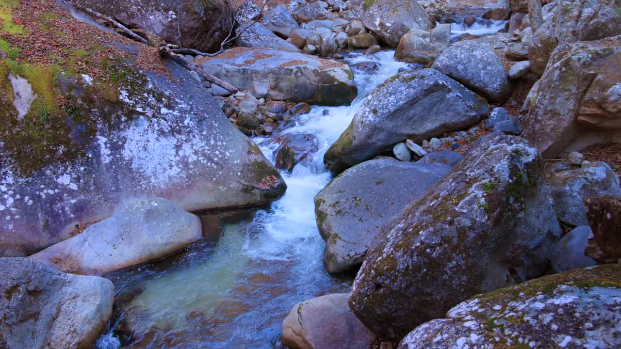 一条纯净的河流流淌在巨大的石块之间