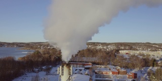 瑞典斯堪的那维亚一个阳光明媚的冬日里，发电厂的烟囱里冒着污染的浓烟发电