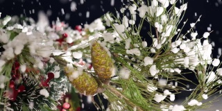 冬夜，圣诞雪花落在松树树枝上，点缀着绿红的花环。